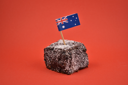 Lamington stock images. Lamington on a red background. Australian sweet delicacy. Important day. Lamington Day background. Australian cake with flagの写真素材