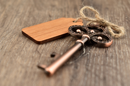 Decorative metal key on a wooden background stock images. Decorated key images. Romantic key with wooden label. Key on the tableの写真素材
