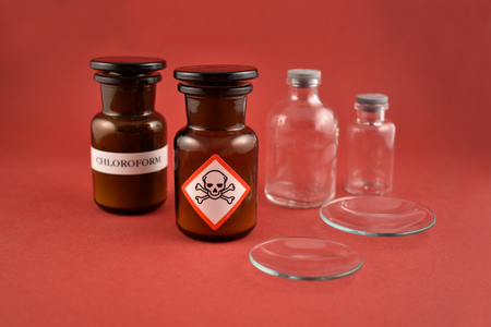 Vial of poison stock images. Vial with warning pictogram stock images. Laboratory accessories. Vials on a red background. Brown glass containers. Brown chemical glassの写真素材