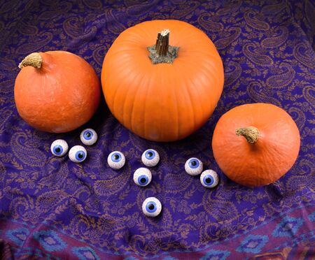 Halloween pumpkin. Three halloween pumpkins with chocolate eyes. Creepy halloween pumpkin. Autumn pumpkin with drapery. Autumn still life with pumpkin. |の写真素材
