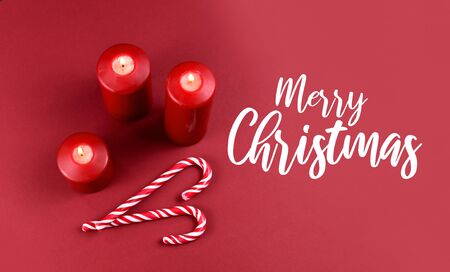Merry Christmas sign stock images. Red Christmas background with candles and candy cane. Christmas still life concept. Christmas candy cane stock images