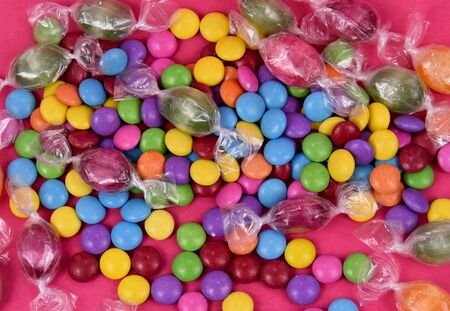 Colorful candies on pink background stock images. Sweets on pink background. Mix of candies....