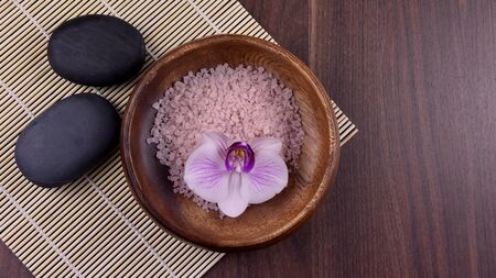 Massage stones with orchid. Spa and wellness setting stock images. Pile of black stones. Black...