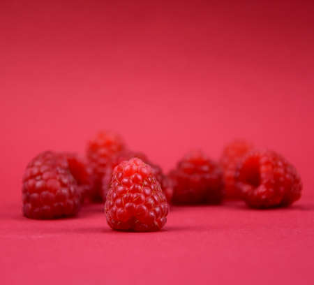 Ripe raspberries frame on a red background stock images. Raspberry berries isolated on a red background with copy space for text. Raspberry red border photo imagesの写真素材