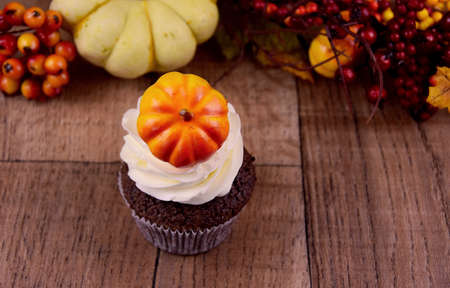 Halloween cupcake with pumpkin on a wooden background stock images. Pumpkin cupcake with vanilla cream stock images. Autumn still life with pumpkin cupcake. Sweet halloween decoration stock photoの写真素材