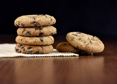 Pile of chocolate chip cookies on a wooden background stock images. Sweet chocolate cookies on the...