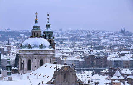 Winter in Prague city stock images. View on snowy rooftops in Prague photo images. View of old town prague city in snowy day in the winter imagesの写真素材