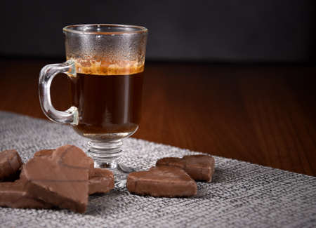 Cup of black hot coffee with chocolate cookies stock images. Glass cup of coffee on the table stock images. Heart shaped chocolate biscuits with a cup of coffee photoの写真素材