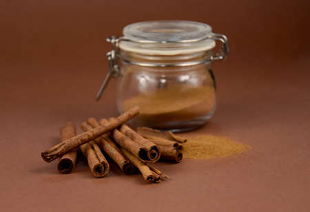 Fragrant cinnamon sticks and powder stock images. Cinnamon sticks on a brown background stock photoの写真素材
