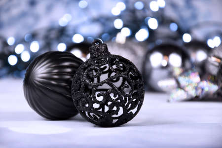 Decorative black and silver christmas balls with lights still life stock images. Elegant black decoration with Christmas garland lights close up stock photo. Black ball ornament imagesの写真素材