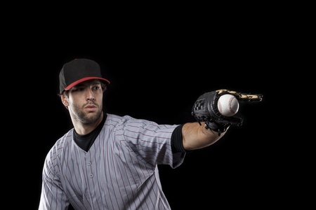 Baseball Player catching a ball on a black background. Studio Shot.の写真素材