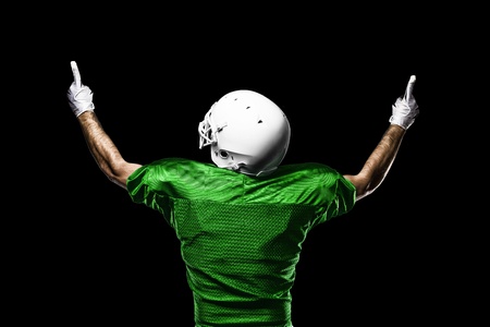 Football Player with a Green uniform celebrating on a black background.の写真素材