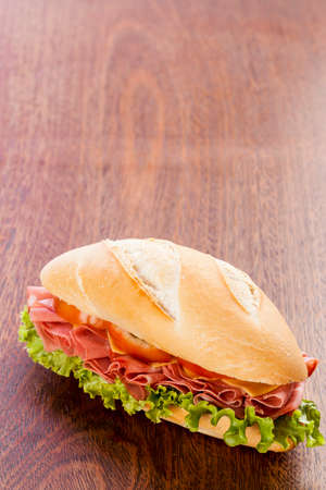 Mortadela sandwich, on a wooden table.の写真素材