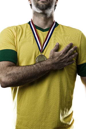 Brazilian soccer player, listening to the national anthem with his hand on his chest, on a white .の写真素材