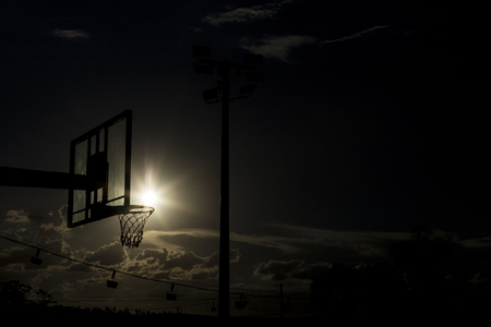 silhouette of a basketball hoop, under the sunset.の写真素材