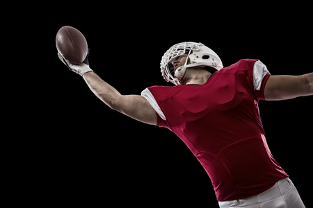 Football Player with a red uniform making a catching on a Black background.の写真素材