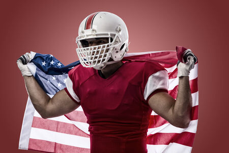 Football Player with a red uniform and a american flag, on a red background.の写真素材