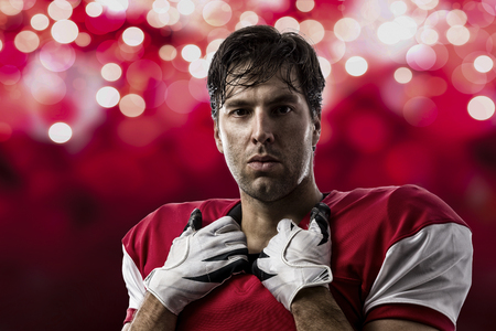 Football Player with a red uniform on a red lights background.の写真素材