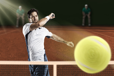 Tennis player playing on a clay tennis court.の写真素材