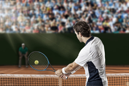 Tennis player returning a ball on a clay tennis court.の写真素材