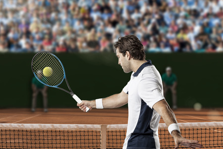 Tennis player returning a ball on a clay tennis court.の写真素材