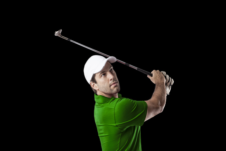 Golf Player in a green shirt taking a swing, on a black Background.の写真素材