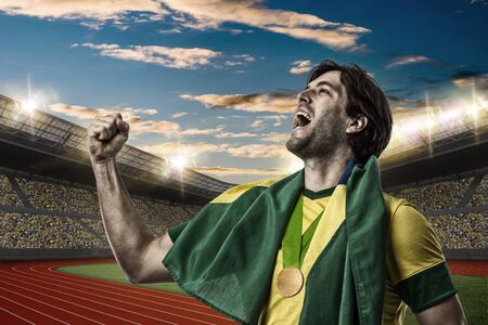 Brazilian Athlete Winning a golden medal on a Track and field stadium.の写真素材