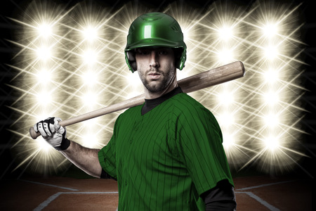 Baseball Player with a green uniform in front of lights.の写真素材