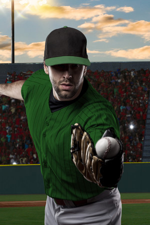 Baseball Player with a green uniform on baseball Stadium.の写真素材