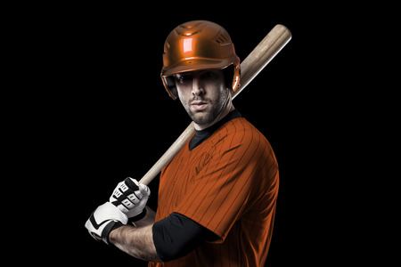 Baseball Player with a orange uniform on a black background.の写真素材