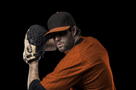 Baseball Player with a orange uniform on a black background.の写真素材