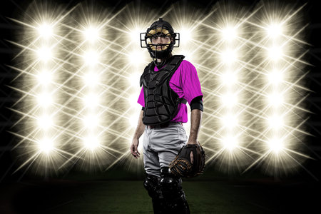 Catcher Player with a pink uniform in front of lights.の写真素材