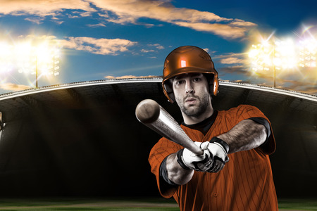 Baseball Player with a orange uniform on baseball Stadium.の写真素材