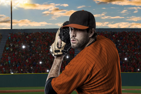 Pitcher Baseball Player with a orange uniform on baseball Stadium.の写真素材