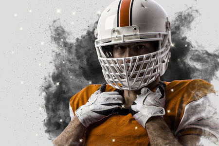 Football Player with a Orange uniform coming out of a blast of smoke .の写真素材
