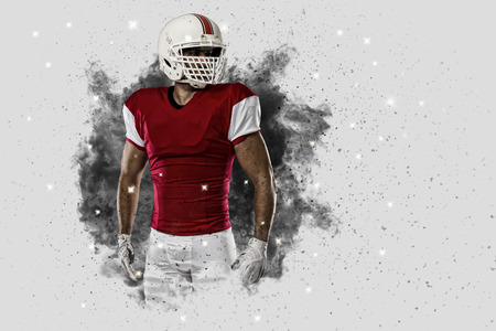 Football Player with a Red uniform coming out of a blast of smoke .の写真素材