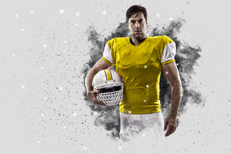 Football Player with a Yellow uniform coming out of a blast of smoke .の写真素材