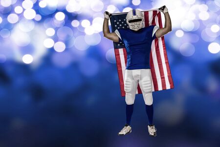 Football Player with a blue uniform and a american flag, on a blue lights background.の写真素材