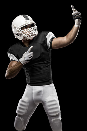Football Player with a black uniform making a selfie on a black background.の写真素材