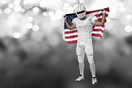 Football Player with a white uniform and a american flag, on a white lights background.の写真素材
