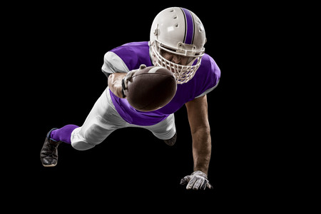 Football Player with a purple uniform scoring on a black background.