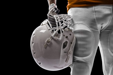 Football Player with a orange uniform on a black background.の写真素材