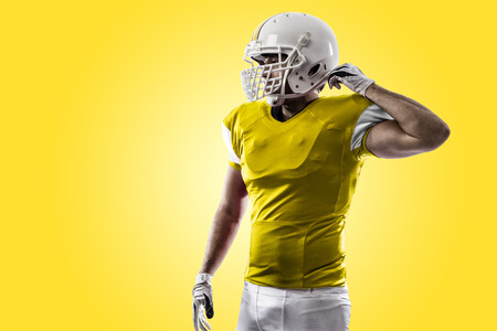 Football Player with a yellow uniform on a yellow background.の写真素材