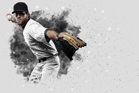 Pitcher Baseball Player with a white uniform coming out of a blast of smoke .の写真素材
