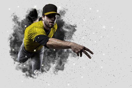 Pitcher Baseball Player with a yellow uniform coming out of a blast of smoke .の写真素材