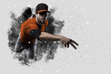 Pitcher Baseball Player with a orange uniform coming out of a blast of smoke .の写真素材