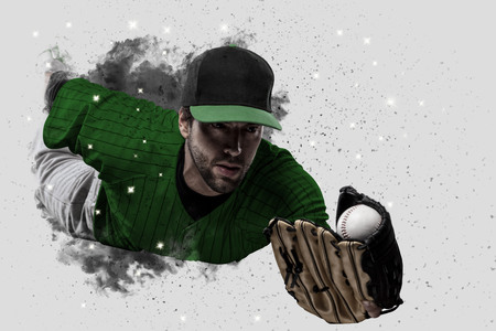 Baseball Player with a green uniform coming out of a blast of smoke .の写真素材
