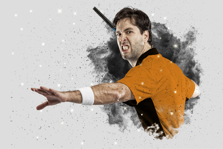 Tennis Player with a orange uniform coming out of a blast of smoke .の写真素材