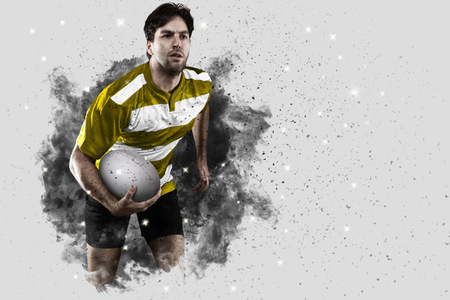 Rugby Player with a Yellow uniform coming out of a blast of smoke .の写真素材