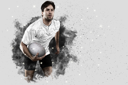 Rugby Player with a white uniform coming out of a blast of smoke .の写真素材